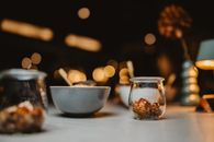 Warm dining table scene with bowls and jars beautifully lit in a cozy ambiance.