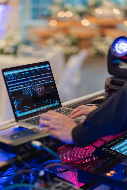 Free DJ performing live music mix at a party event with dynamic lighting and sound equipment. Stock Photo