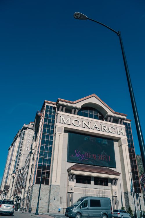 Free Front view of Monarch hotel with clear blue sky, and cars passing by on a sunny day. Stock Photo
