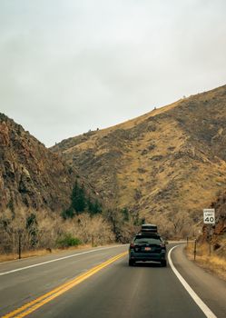 Car journey through a mountain road with a speed limit sign, surrounded by rugged terrain.