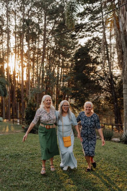 Three senior women walking together in a scenic outdoor setting in Brazil, showing joy and companionship.
