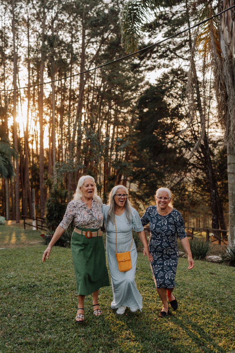Three senior friends laughing together outdoors