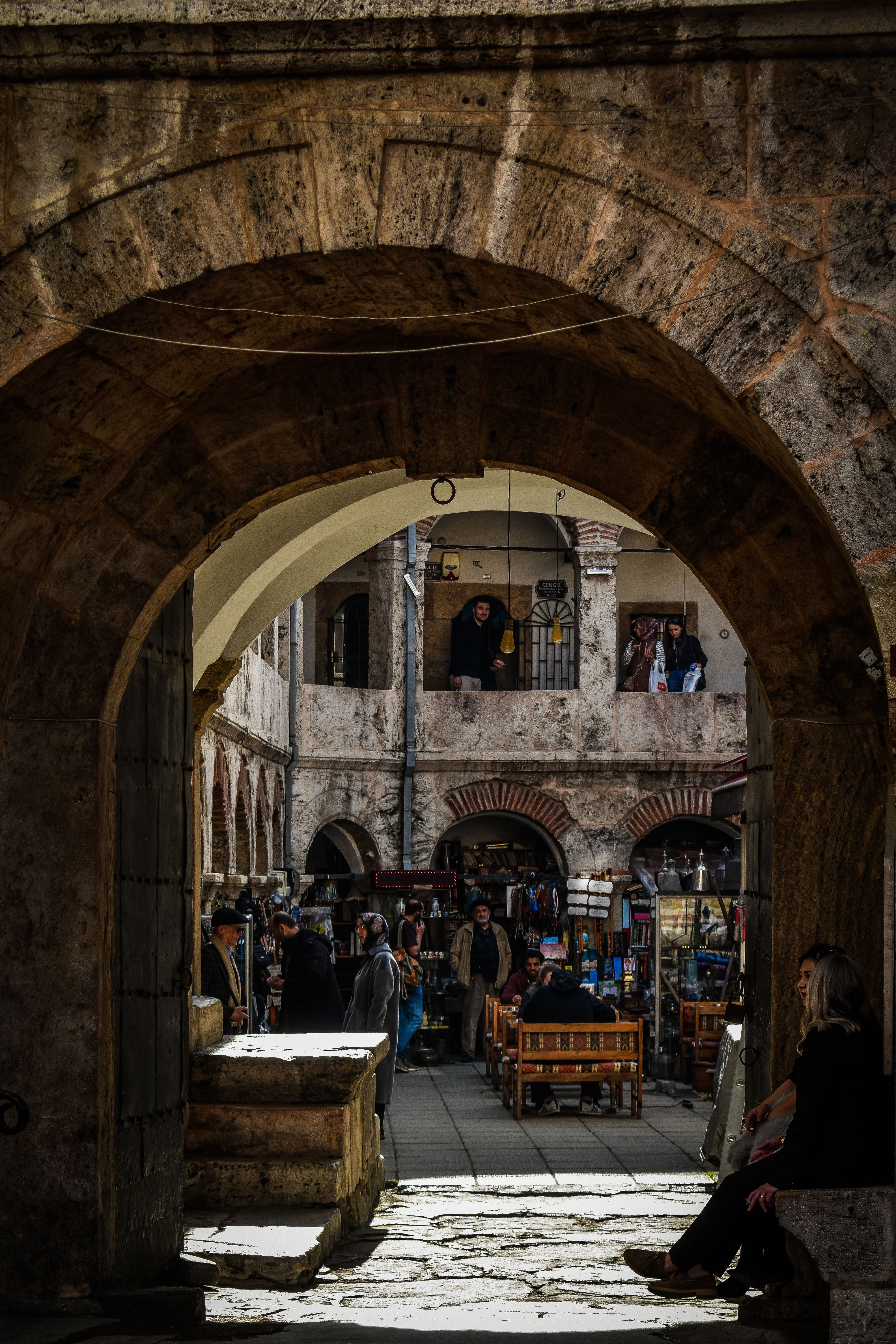 A bustling historic market with arches and people, capturing the charm of an old-world courtyard.