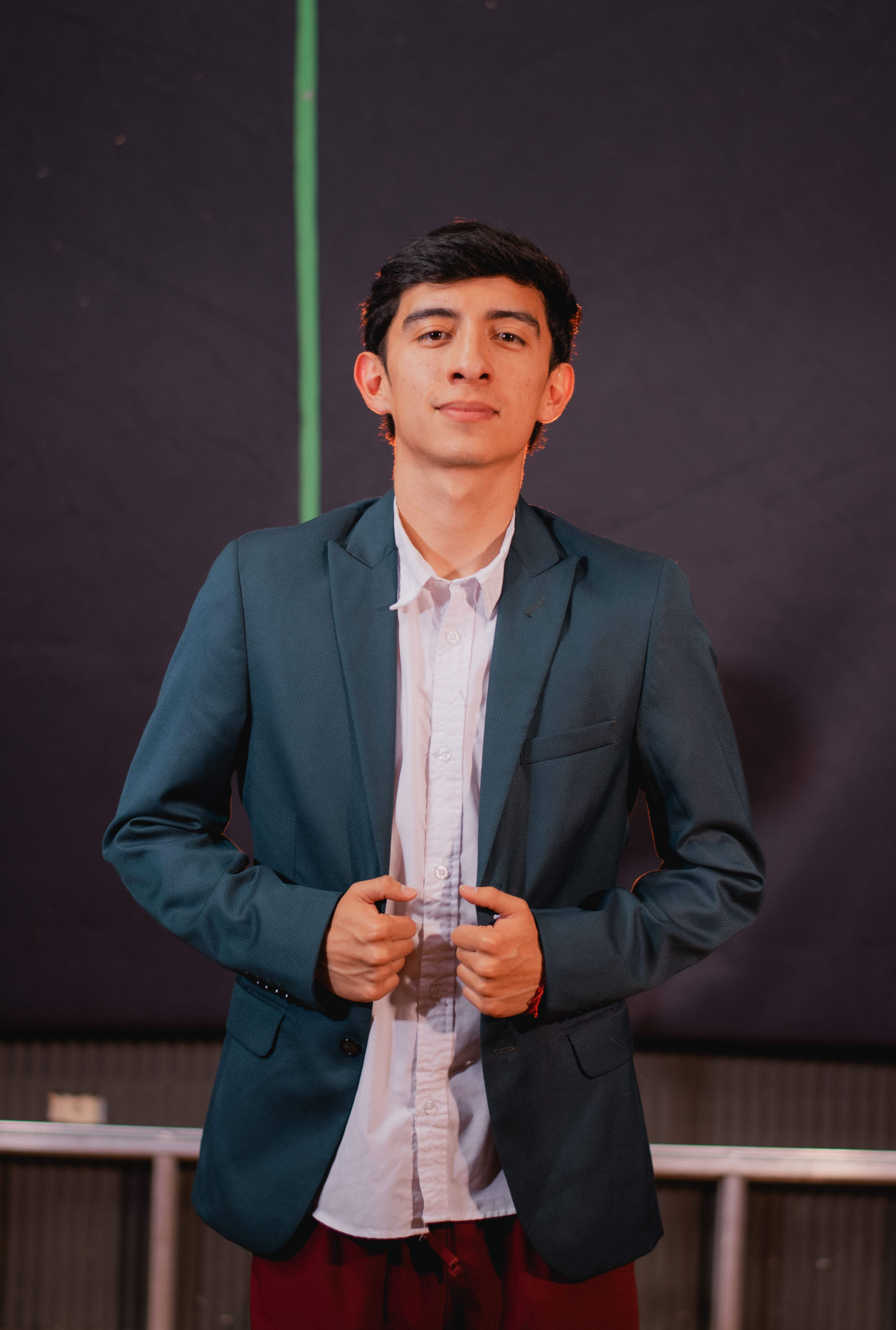 Fotomural Retrato de un joven seguro en un traje elegante contra un fondo oscuro.