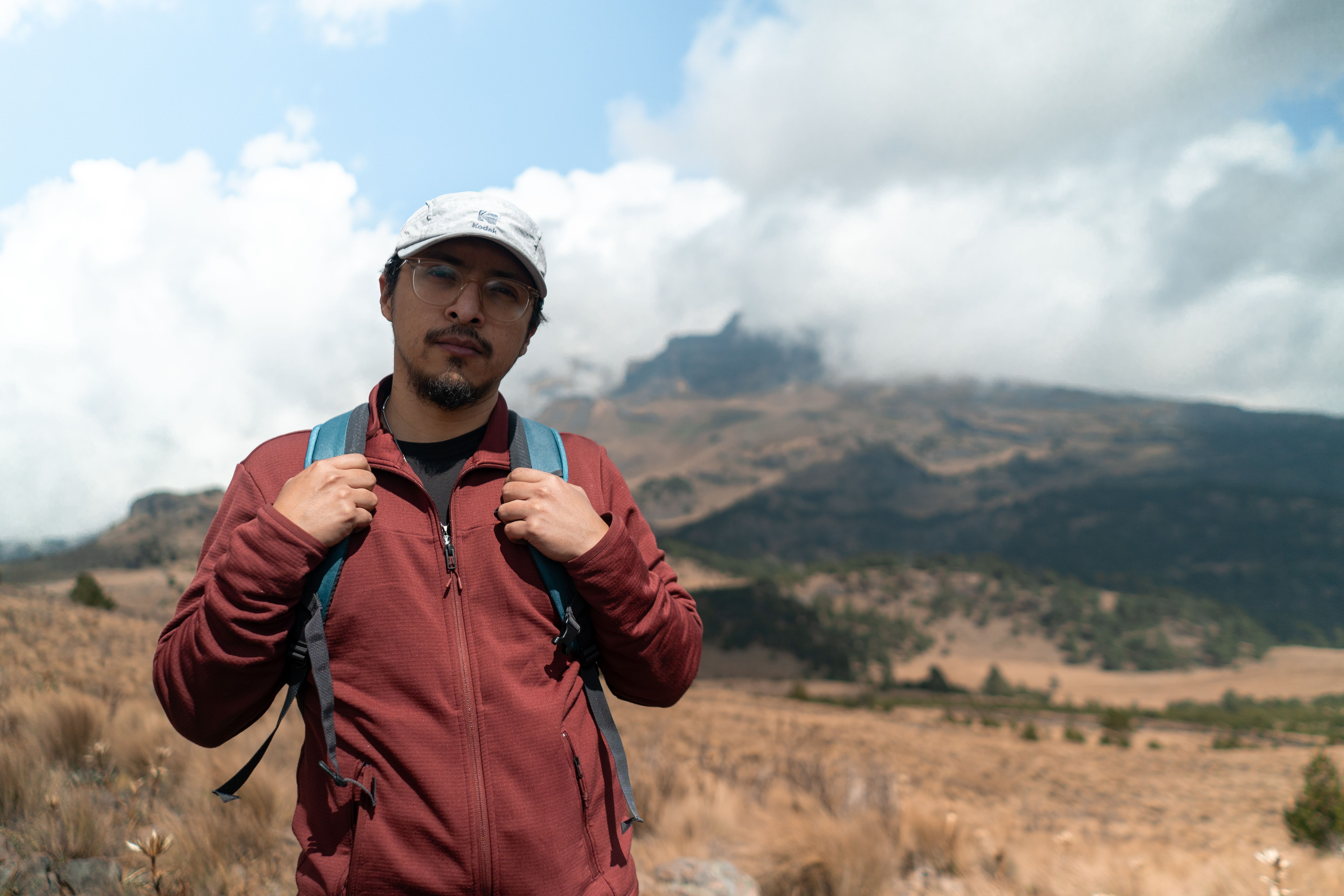 Man hiking in scenic mountain area with backpack, enjoying adventure.