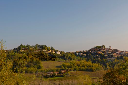 Captivating landscape of Cella Monte showcasing lush hills and charming architecture under a clear sky.