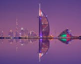 迷人的夜间场景中，阿拉伯塔和迪拜天际线的倒影交相辉映