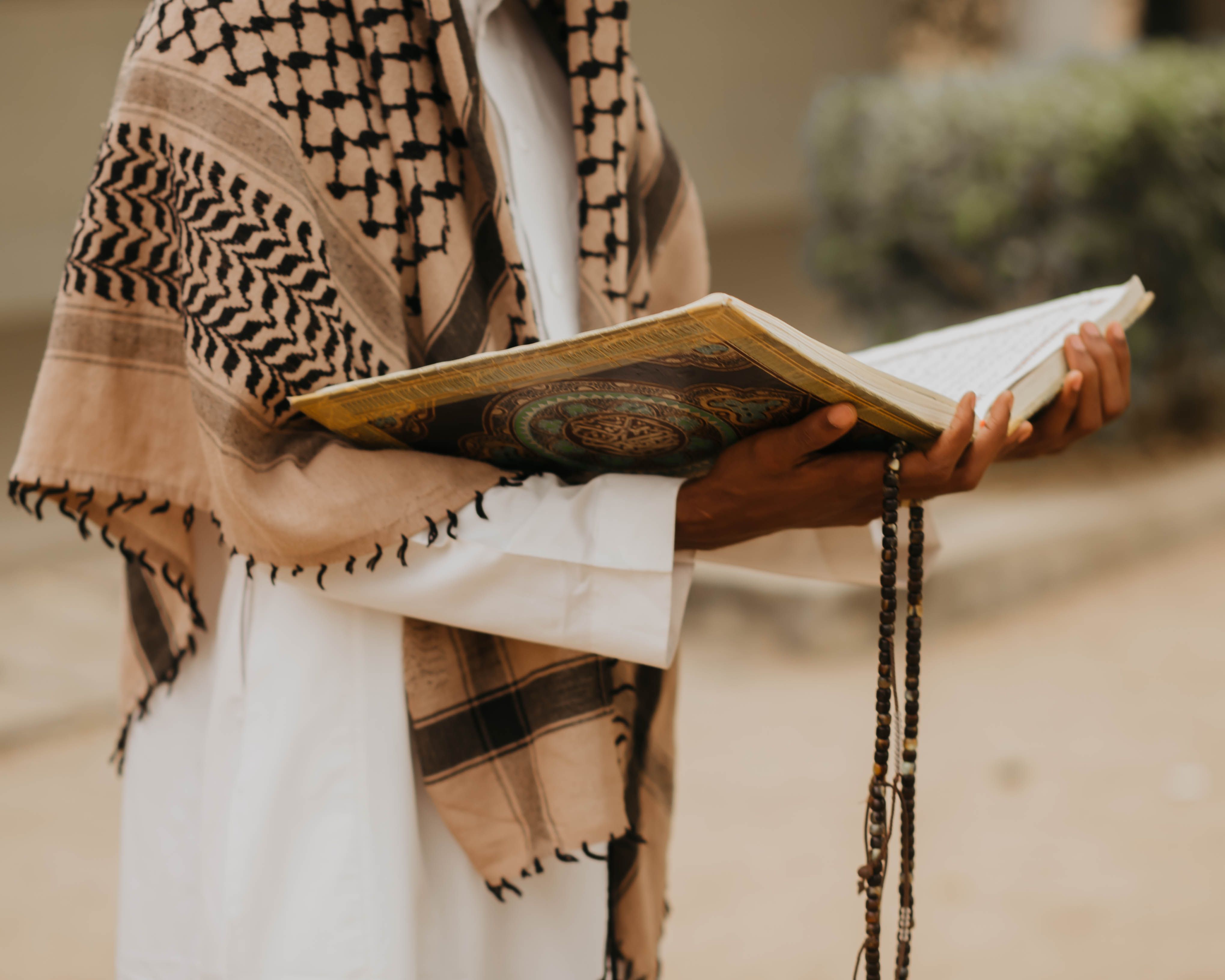 Person Reading Religious Text with Rosary Beads · Free Stock Photo