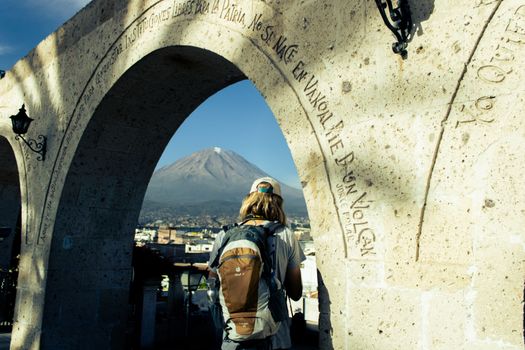 A traveler gazes at the Misti volcano from under the iconic Yanahuara Arch in Arequipa, Peru.