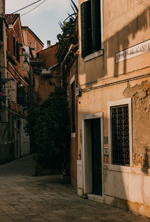 Free Explore a serene alleyway in Venice, Italy, showcasing historic architecture in warm evening light. Stock Photo