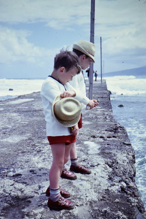 Children Standing on Beach Shore Watching The Waves