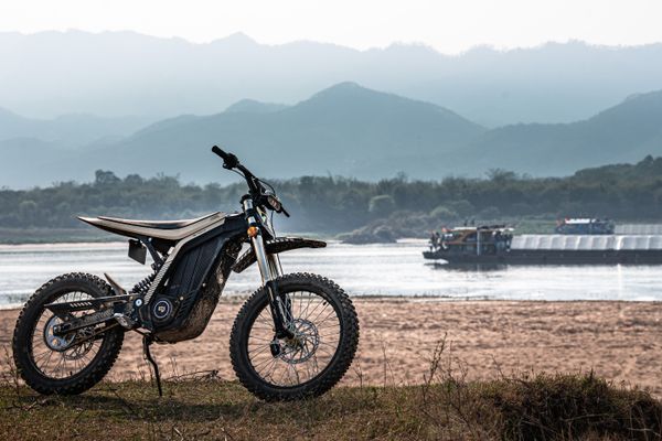 Electric dirt bike by the river at golden hour