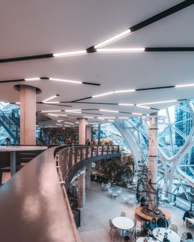 现代室内空间以未来主义建筑、玻璃板和郁郁葱葱的绿色植物为特色