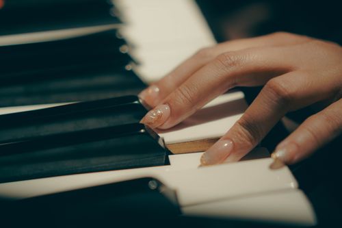 Free A detailed close-up of a person's hand playing piano keys, emphasizing musical expression. Stock Photo
