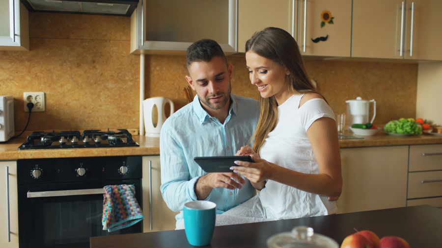 Couple using a tablet together in a kitchen — photo by Vitaly Gariev on Pexels