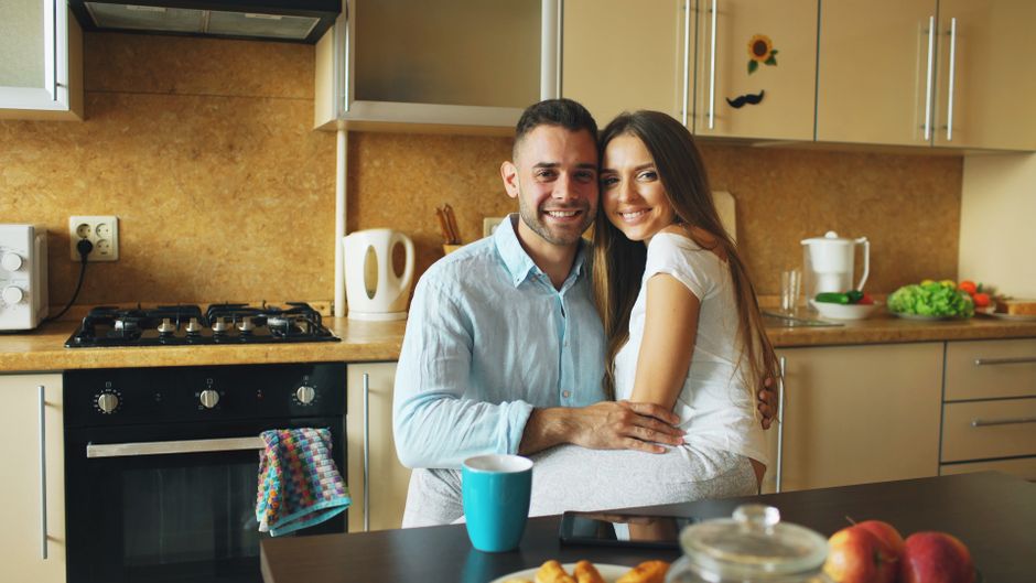 Happy couple embraces in a cozy kitchen setting, embodying warmth and positivity.