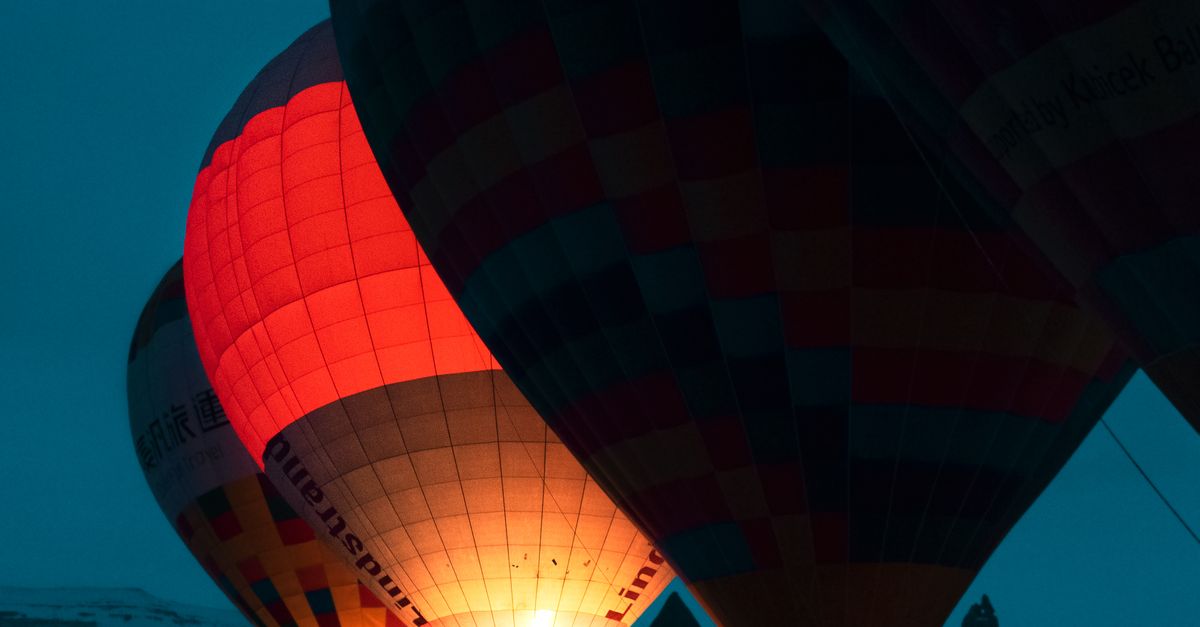 Rüyada Sevgiliyle Balona Binmek - Rüya Tabiri ve Anlamı - Glowing hot air balloons preparing for a flight at night in Cappadocia, Turkey.
