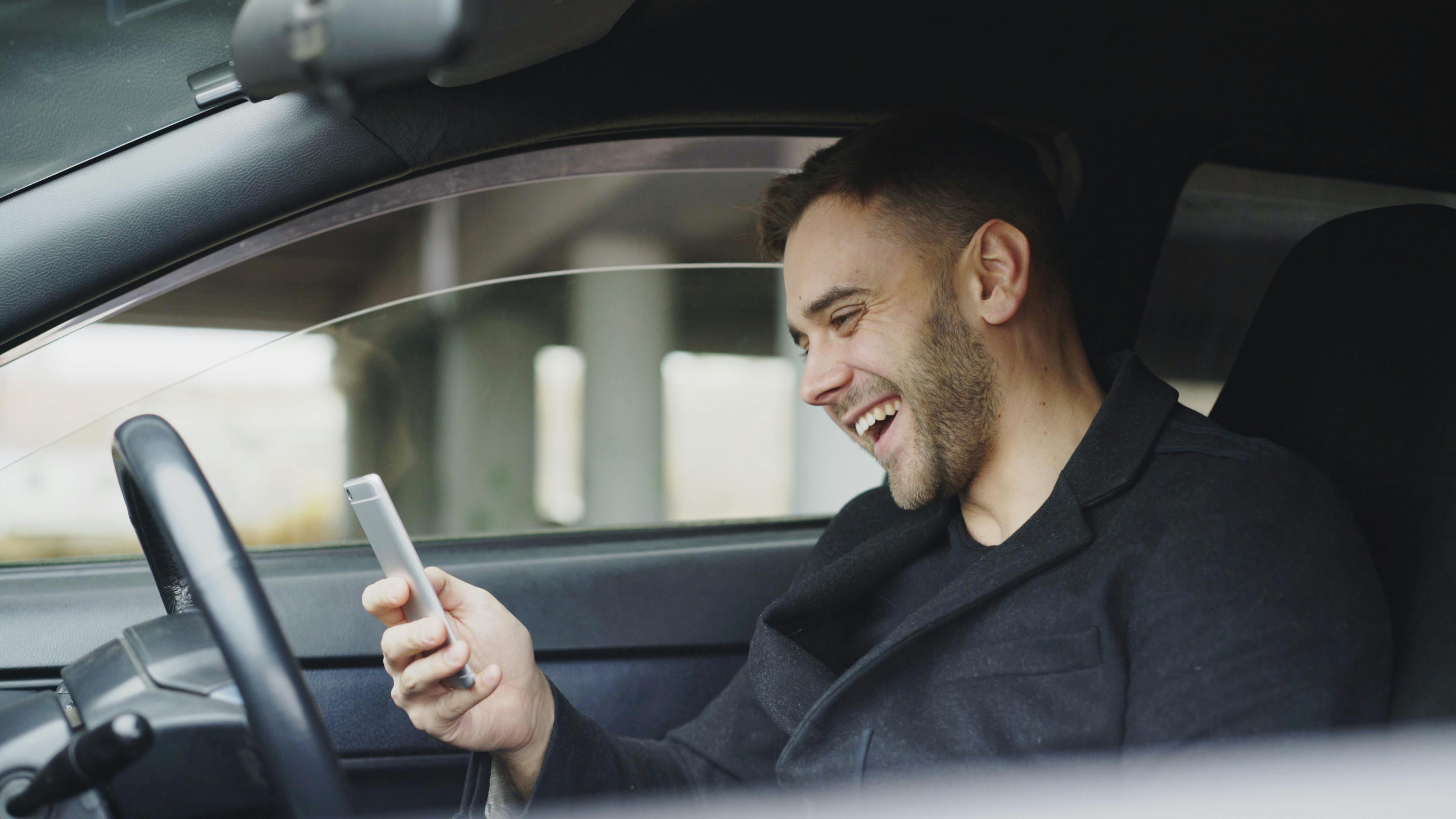 Young hispanic man in Fort Myers looking at phone WhatsApp chat about car insurance