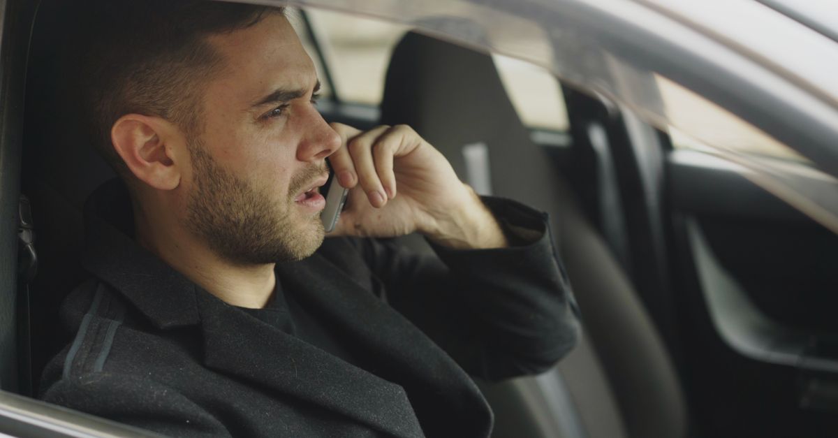 Young hispanic man on phone WhatsApp chat with insurance agent in car Lakeland Florida