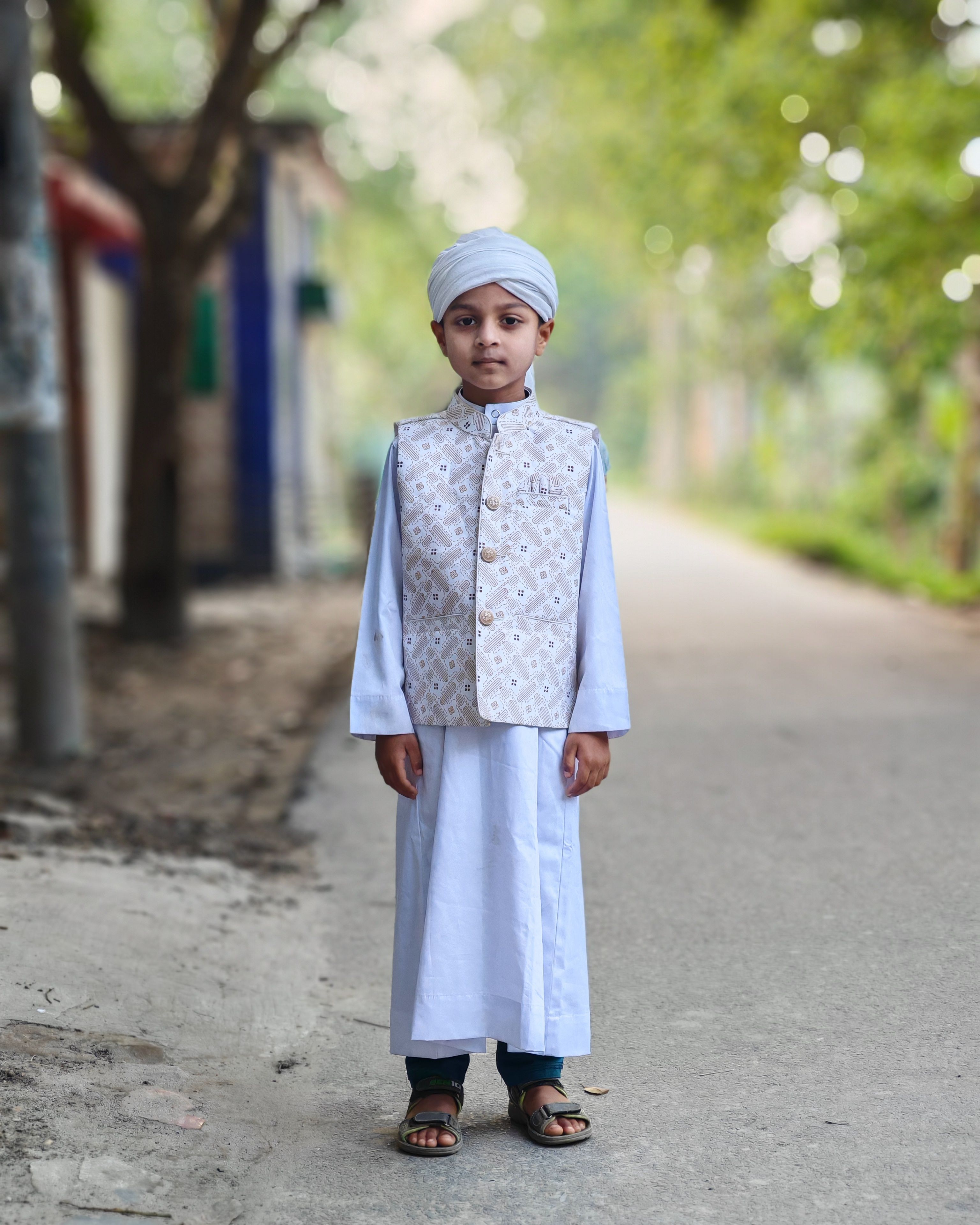 Young Boy in Traditional Attire on a Village Path · Free Stock Photo