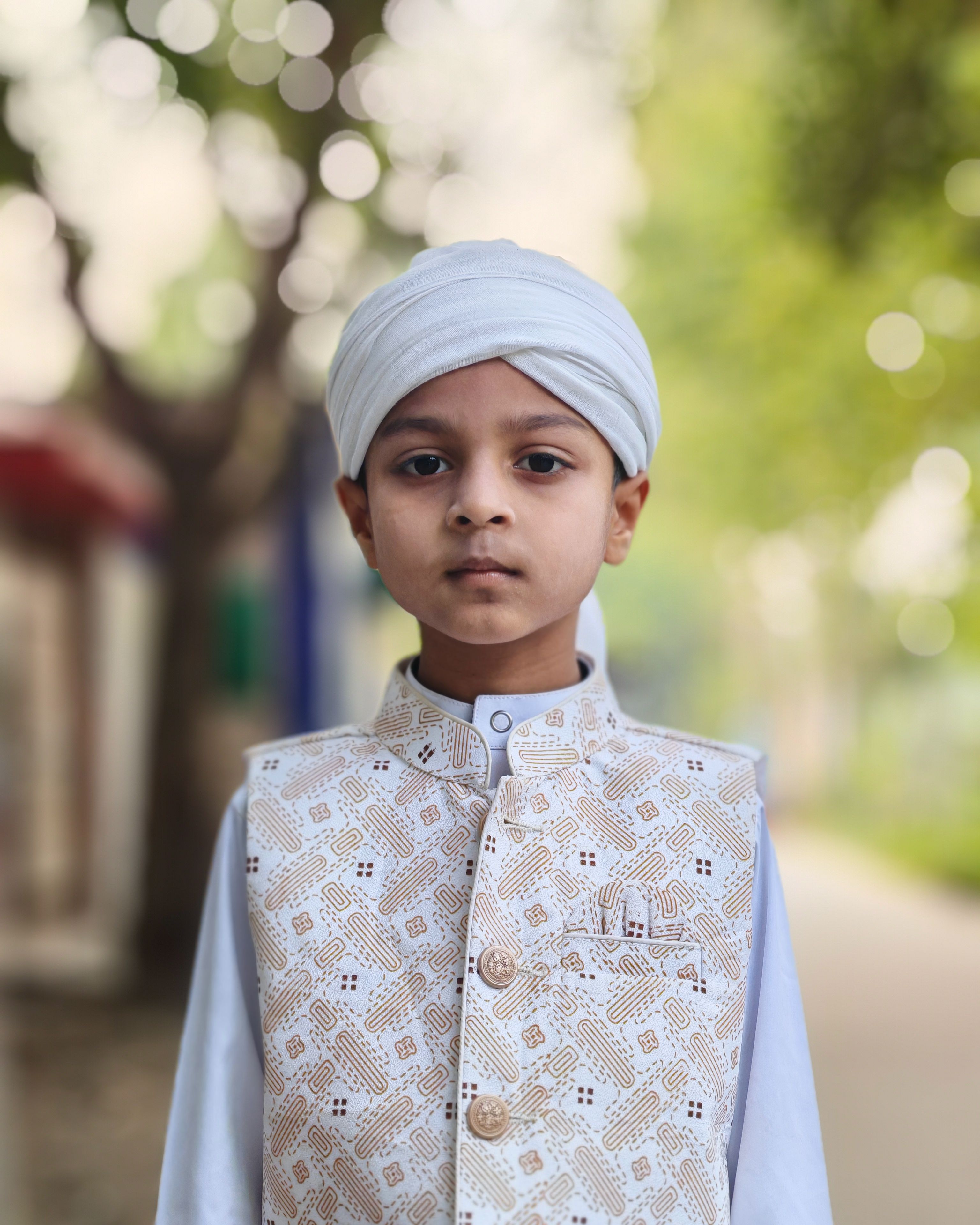 Portrait of a young boy in traditional attire with a serene background, conveying cultural richness.