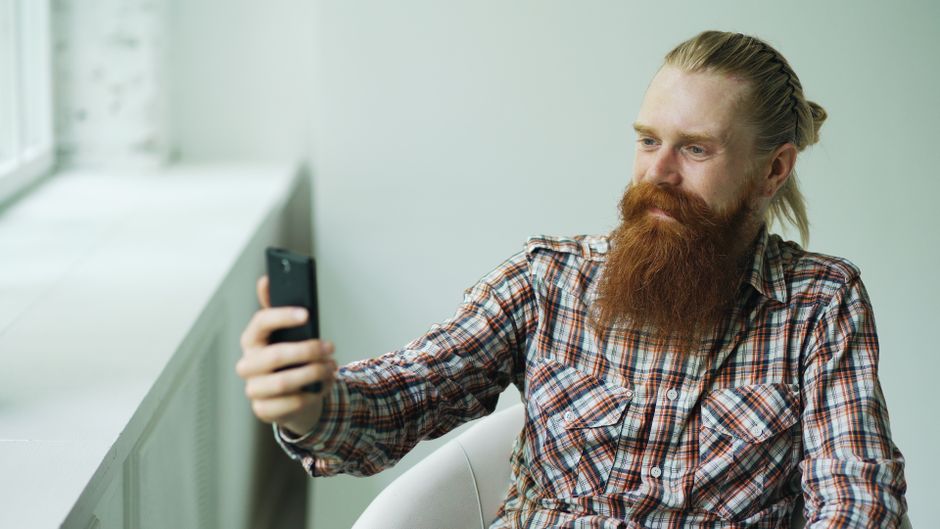 A person photographing a paper check with their phone to make a mobile deposit