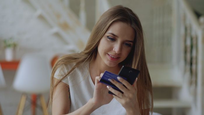 Someone checking a balance on a phone, photo by Vitaly Gariev on Pexels