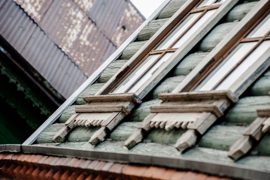 Close-up of a rustic wooden house's windows and shutters, showcasing vintage architecture.