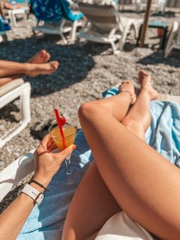 Enjoying a sunny day at the beach with a cocktail in hand, creating the perfect summer vibe.