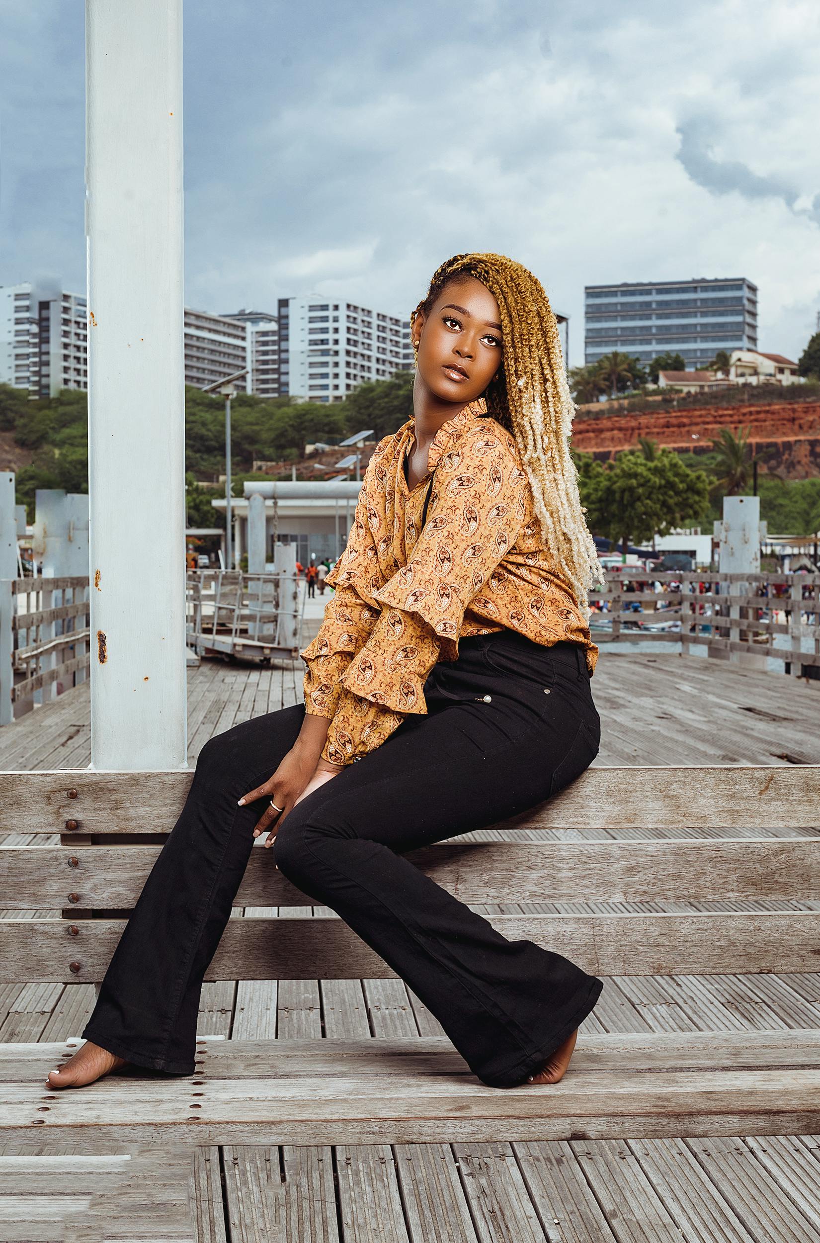 在城市环境中，一位自信的年轻女子坐在木凳上