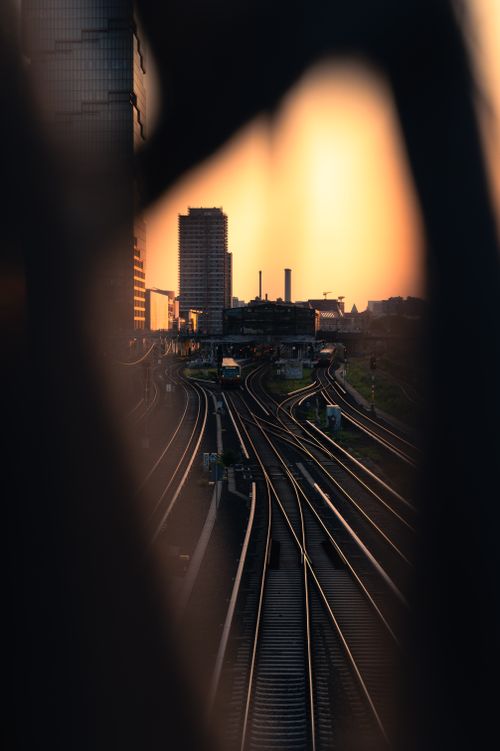 Free A vibrant sunset casts a warm glow over railway tracks in Berlin's urban landscape, showcasing modern architecture. Stock Photo