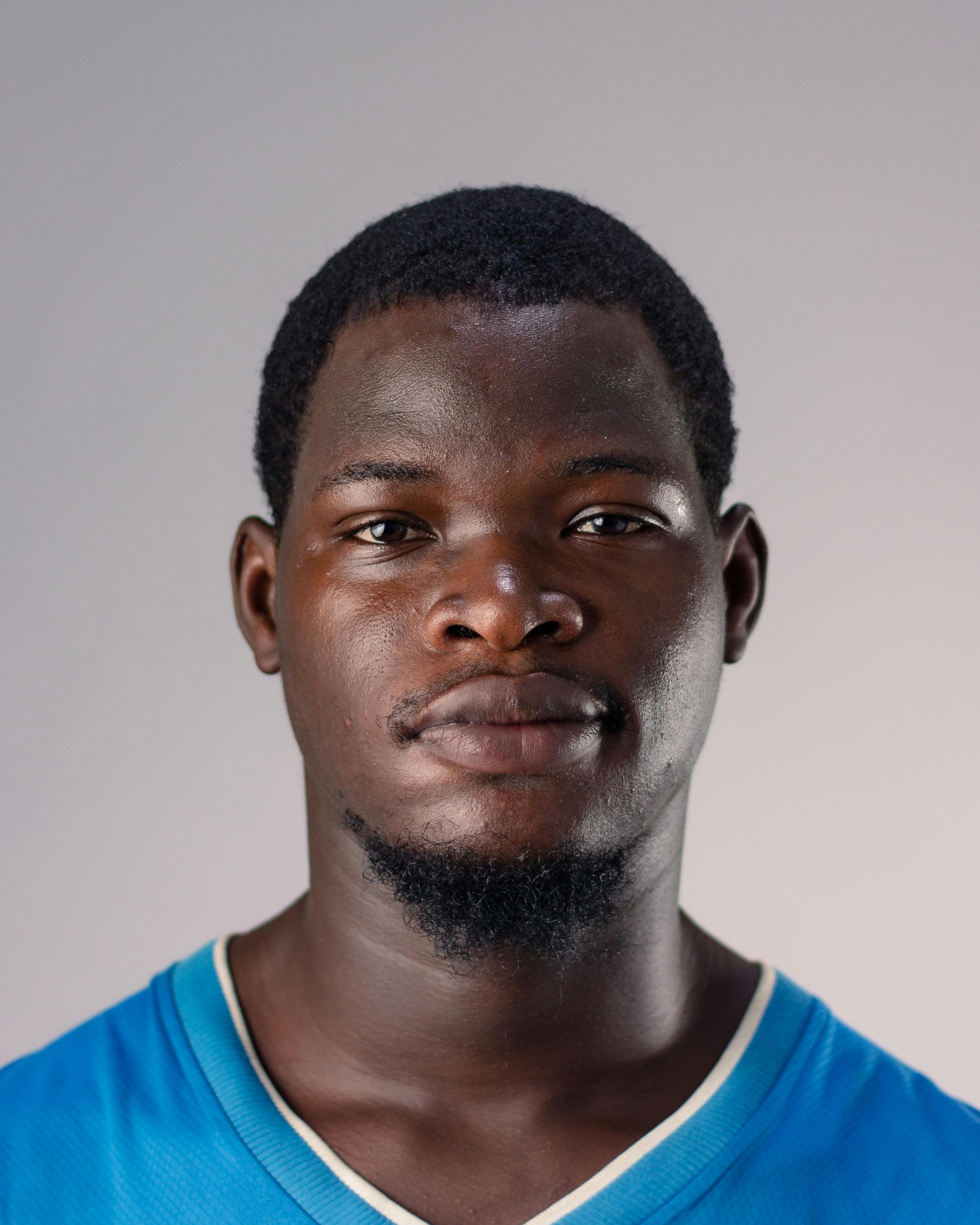 Close-up portrait of a young man with neutral background, natural expression.