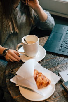 这家咖啡馆氛围温暖，提供咖啡和羊角面包，并设有适合休闲办公的笔记本电脑工作区