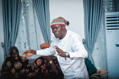 Free A group of Nigerian men enjoying a lively traditional celebration indoors. Stock Photo