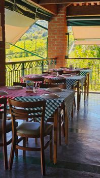 Cozy outdoor dining setting with checkered tablecloths and lush greenery in São Paulo, Brazil.