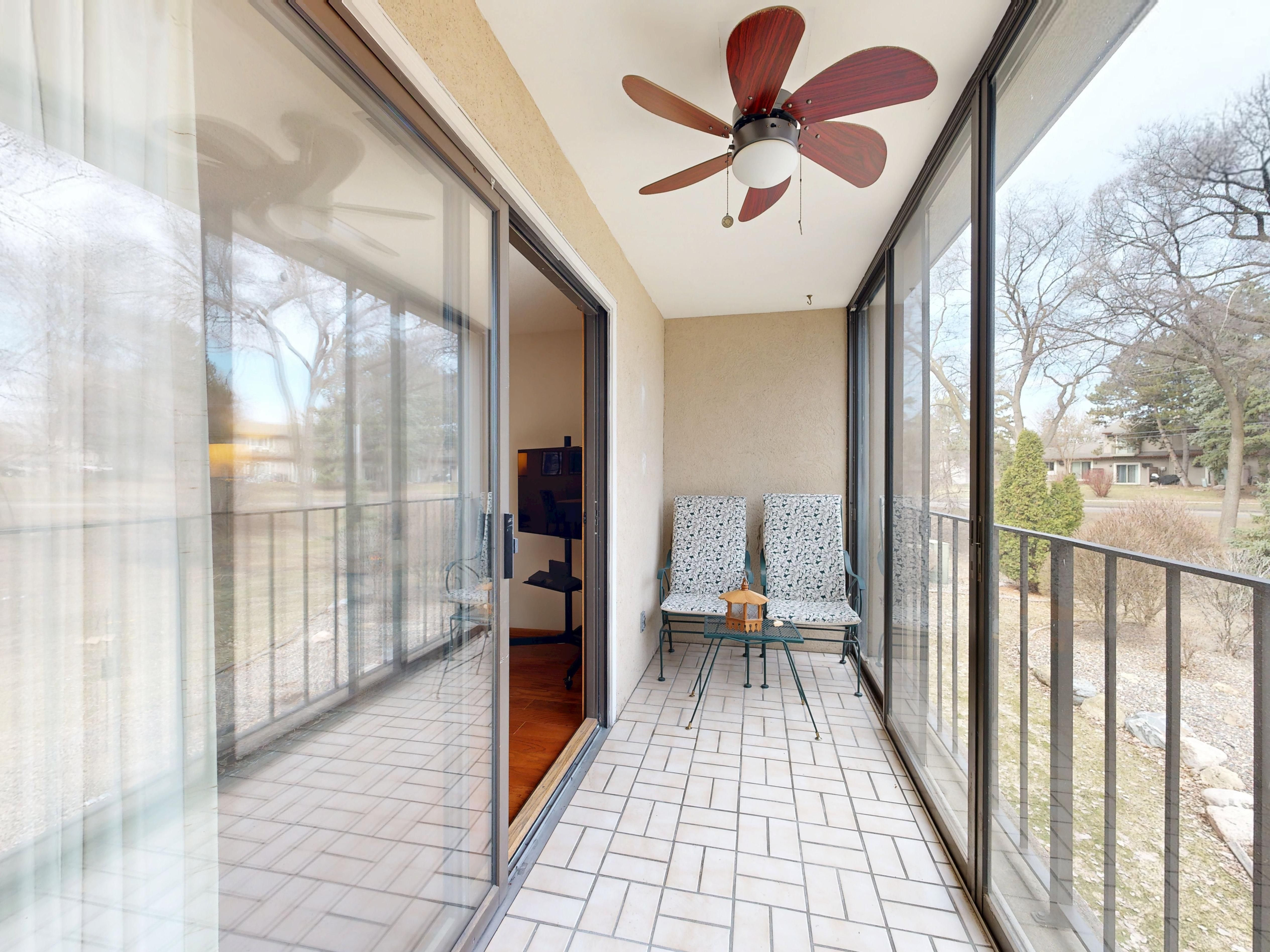 Balcony with chairs and a ceiling fan