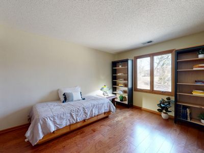 Twin room with bookshelves and a garden window, photo by Peter Vang on Pexels