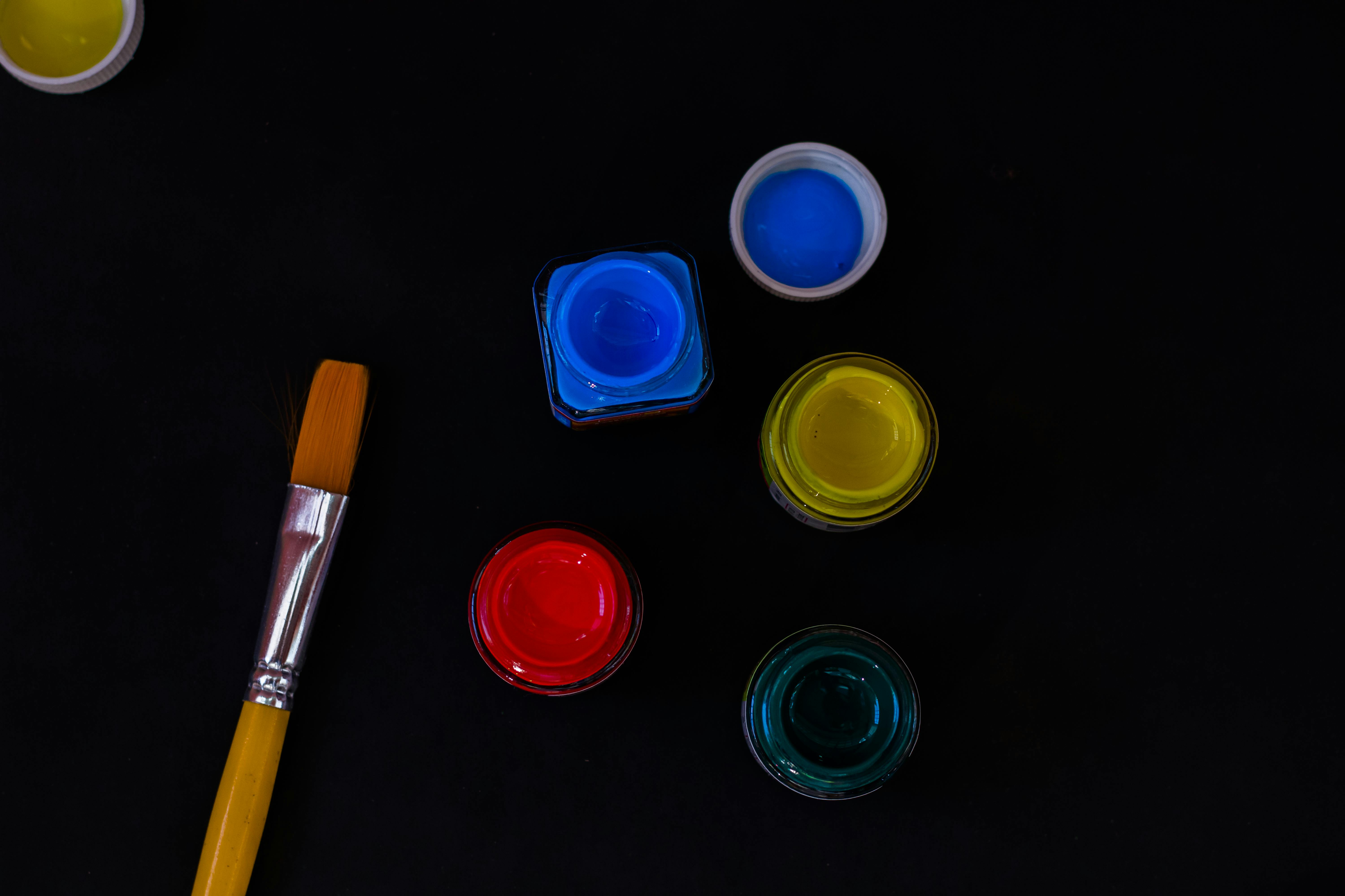 A Paint Brush And Acrylic Paint In Black Background Free Stock Photo