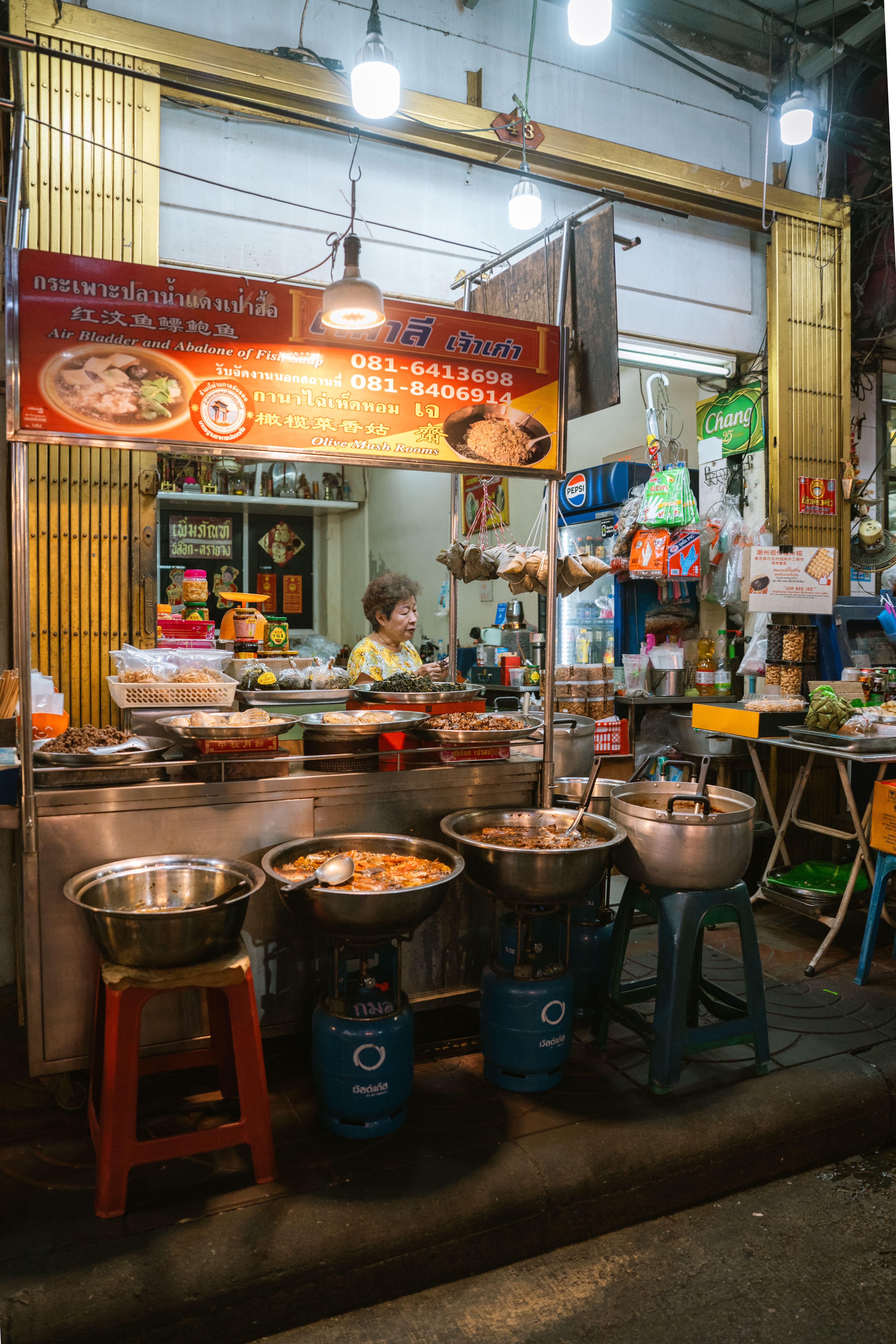 A vibrant street food stall in Bangkok showcasing a variety of traditional Thai dishes at night.