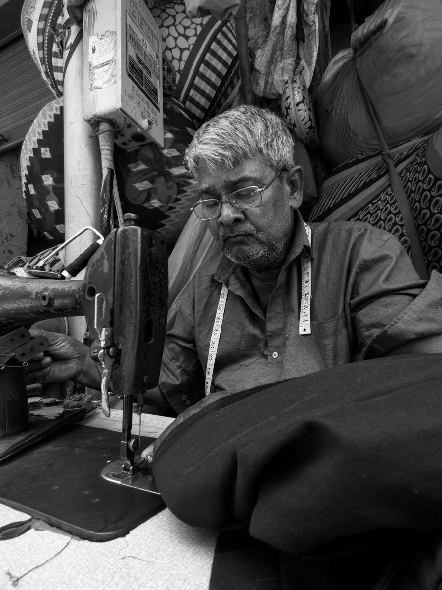 An Indian tailor at work in his workshop
