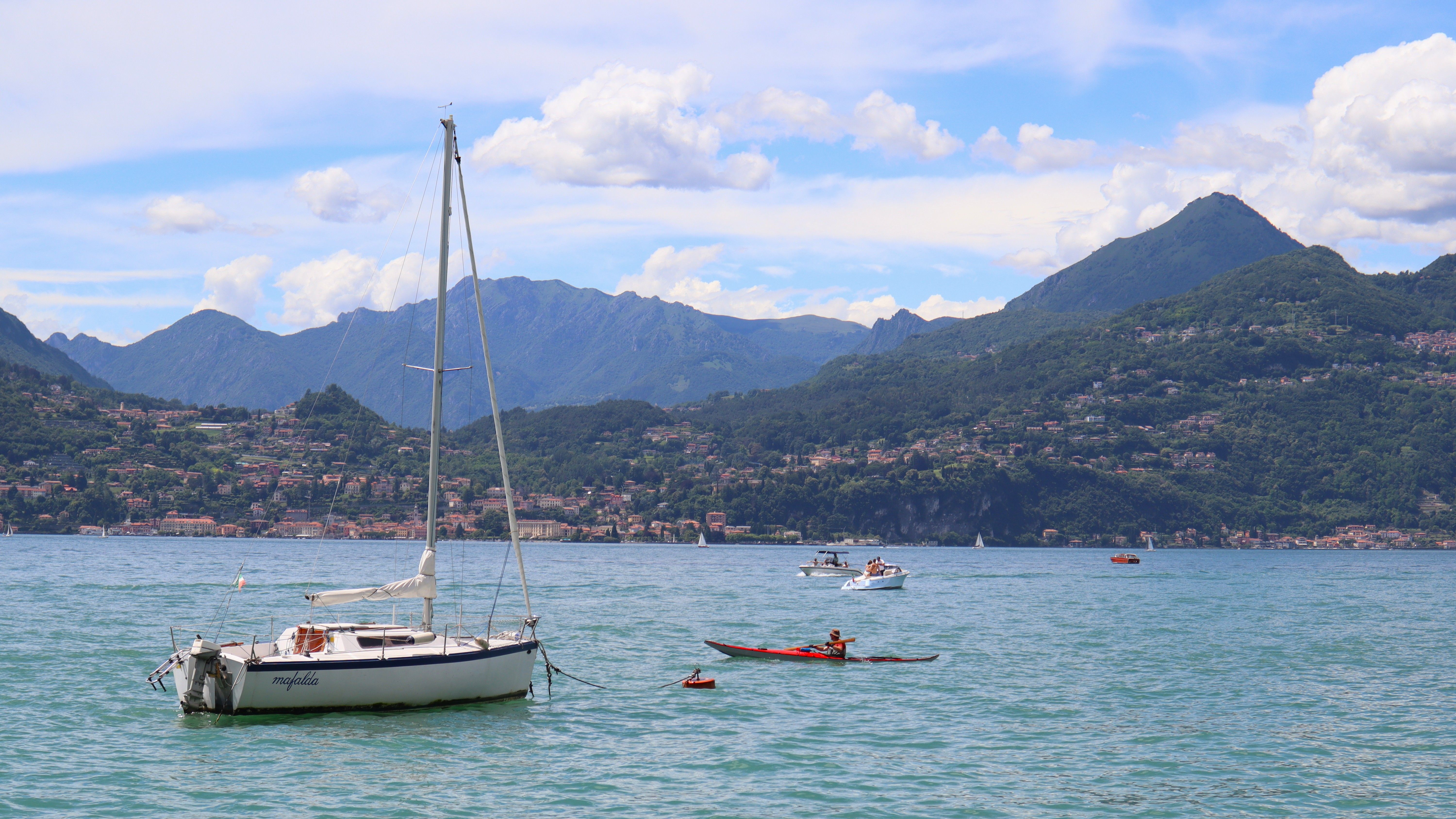 Spectacular Private Luxury Yacht Tour of Capri from Rome by Train Review 2026 - Scenic view of sailboats on Lake Como in Lombardy, Italy, surrounded by mountains.