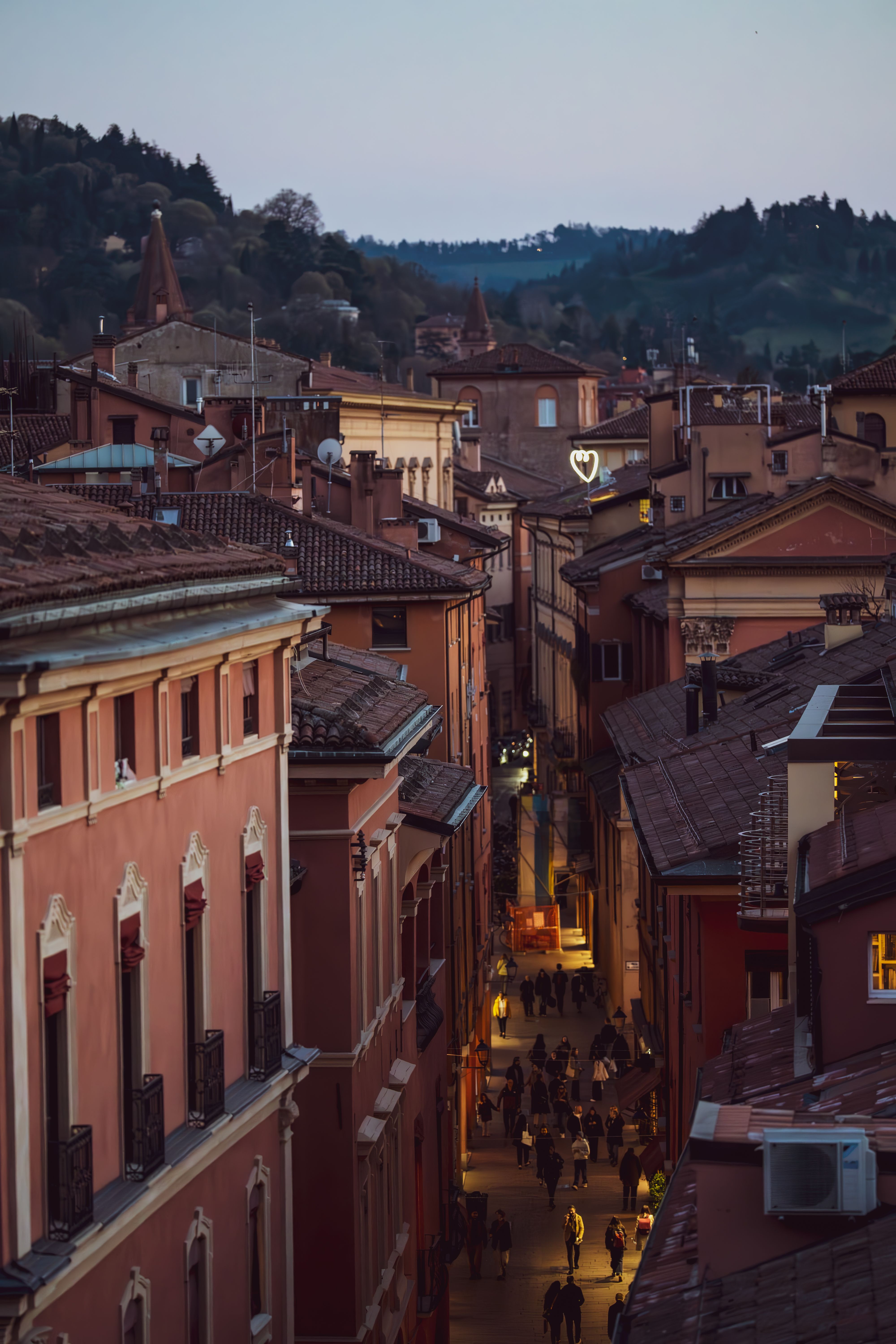 Scenic evening view of Bologna's historic street in Italy, with warm lighting and lively atmosphere.