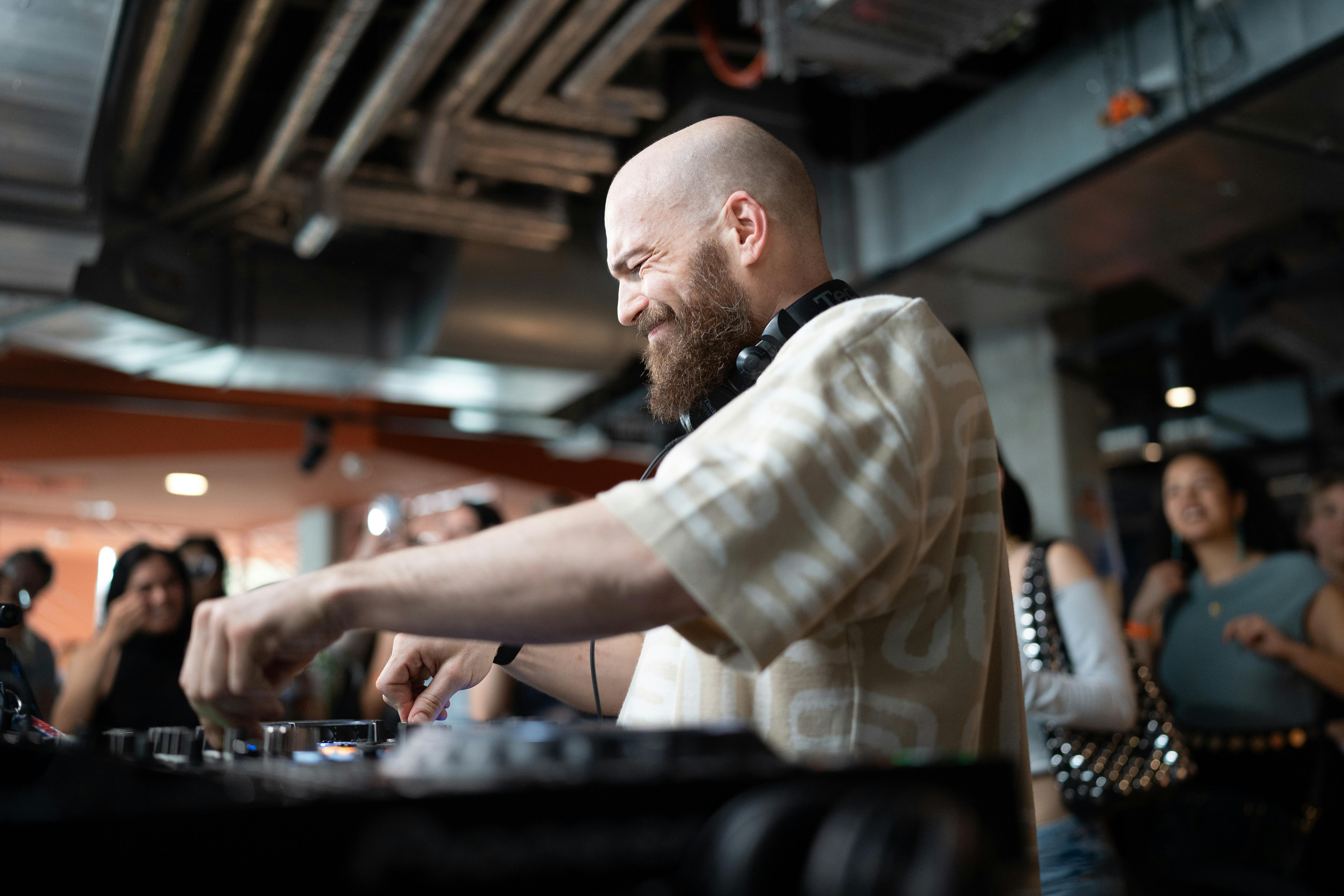 Energetic DJ mixing tracks in a lively indoor club environment.