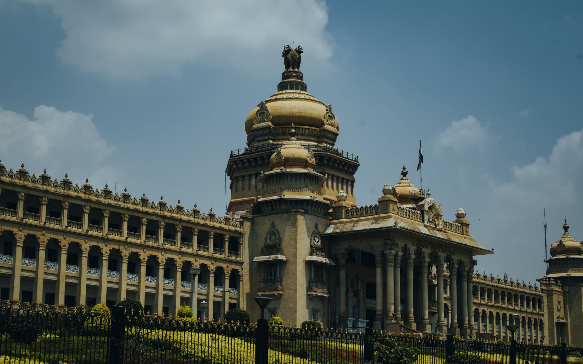 The majestic Vidhana Soudha in Bengaluru captured under a vibrant blue sky.