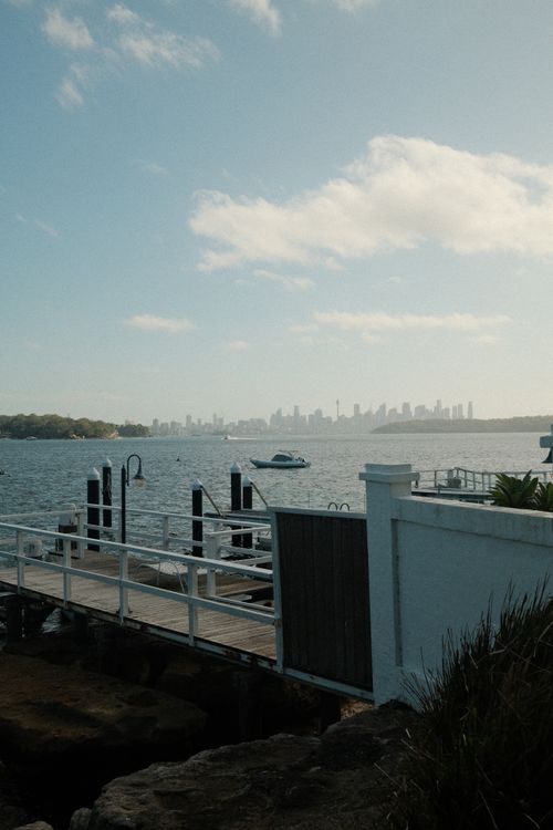Free Tranquil Sydney harbour scene with the city skyline in the background, showcasing a serene waterfront view. Stock Photo