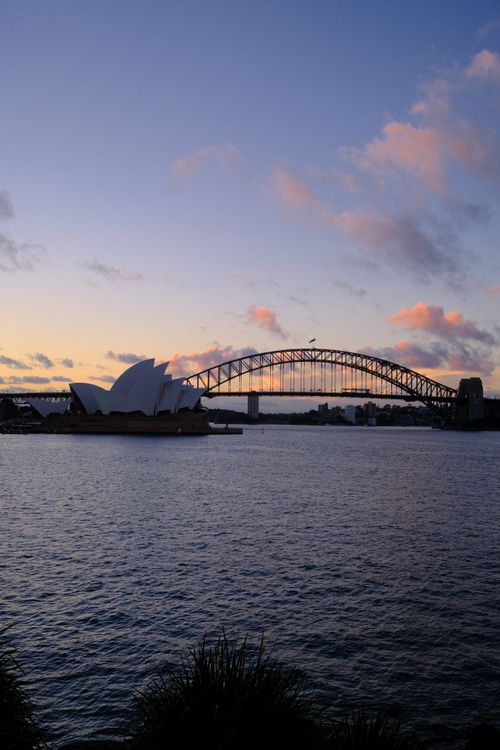 Free Stunning sunset view of the iconic Sydney Opera House and Harbour Bridge in Australia. Stock Photo
