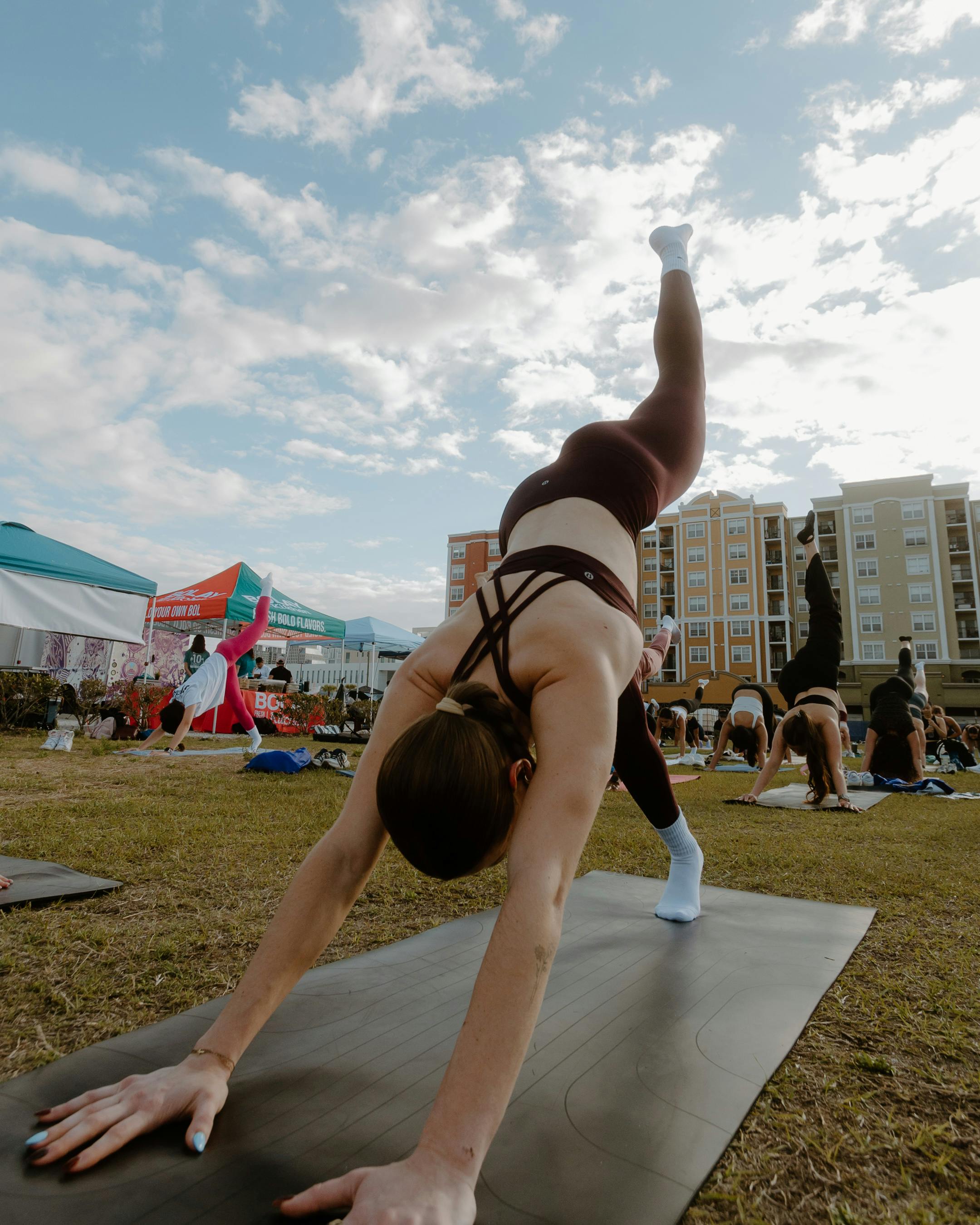 Group of women practicing yoga outdoors in a city park. Fitness and wellness in urban lifestyles.