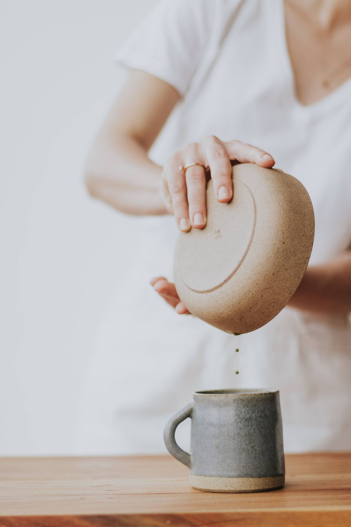 Tea being poured into a handcrafted ceramic mug