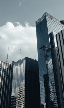 Dramatic view of São Paulo's modern skyscrapers under a cloudy sky.