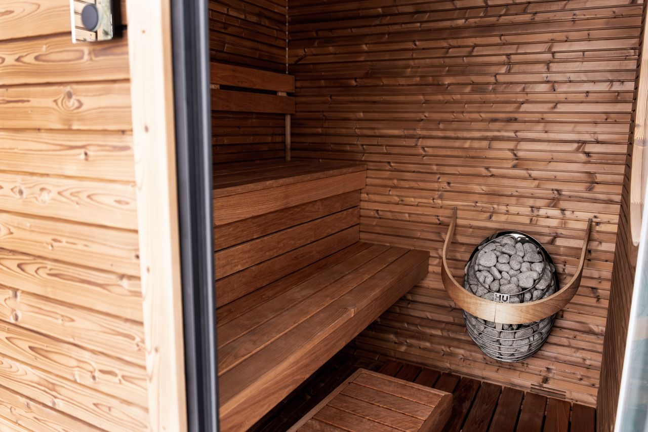 Nordic sauna at Nāra, timber-lined with a low bench and warm light